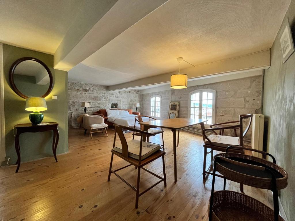 a dining room with a table and chairs and a living room at Gite du Clocher de la Cathédral charmant duplex in Périgueux