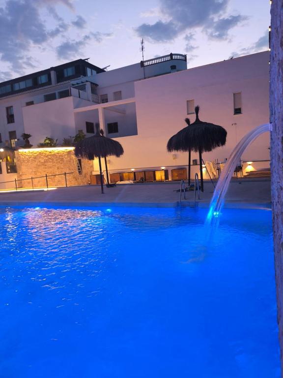 a swimming pool with blue water in front of a building at Hotel Avenida Tropical by Bossh! Hotels in Salobreña