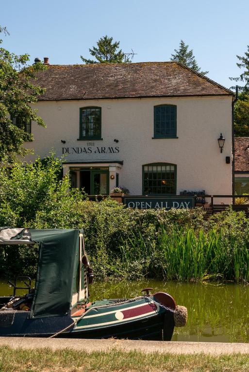 a boat in the water in front of a building at The Dundas Arms in Kintbury