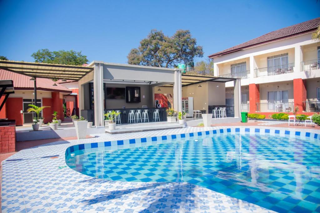 a swimming pool in front of a house at Chamba Valley Exotic Hotel in Lusaka
