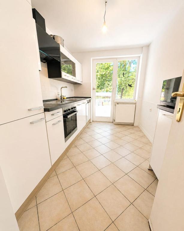 a kitchen with white appliances and a tile floor at Arkadia Monteur-Haus Seevetal in Seevetal