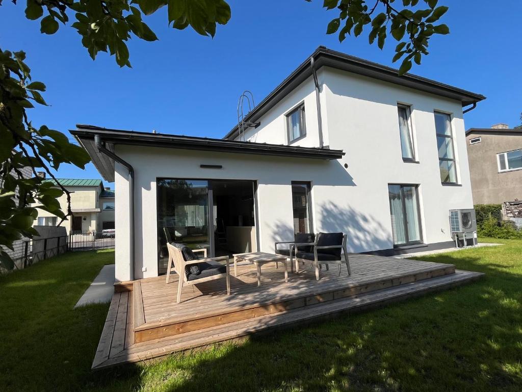 a house with a wooden deck in the yard at Villa Eha in Kuressaare