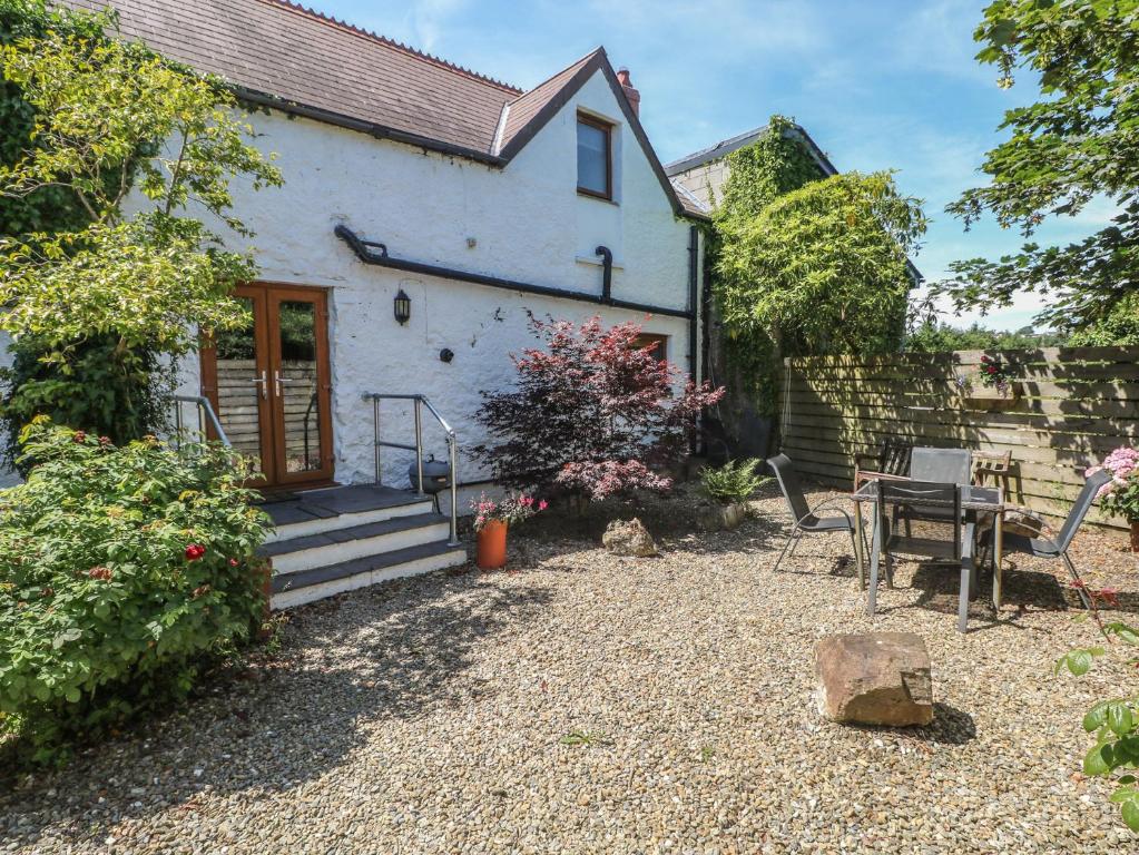 a white cottage with a patio and a table at Stable Cottage, Narberth in Narberth