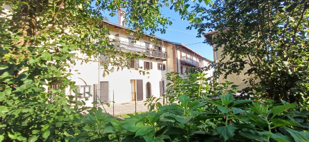 a building with a balcony in the middle of trees at Nespello Tourist Accommodation in Costa di Serina