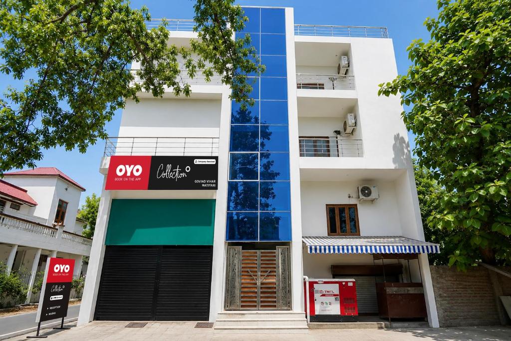 a white building with aoc clinic sign in front of it at OYO Collection O Govind Vihar Matiyari Formerly Saffron in Lucknow