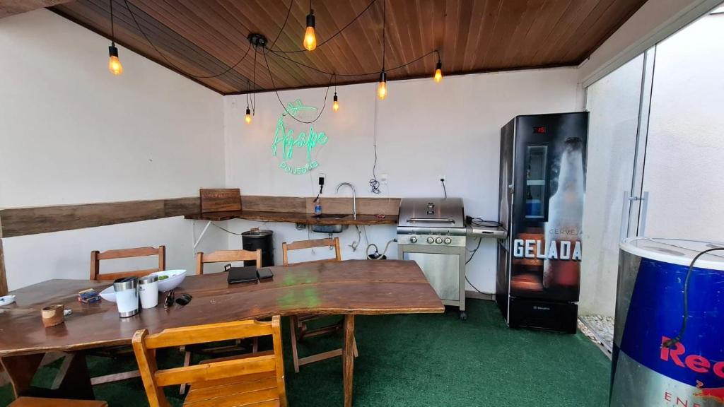 a kitchen with a large wooden table and a refrigerator at Pousada Ágape in Chapada dos Guimarães