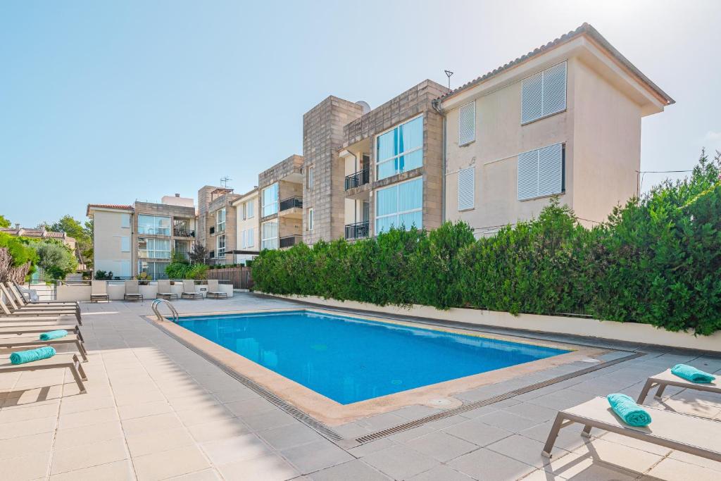 a swimming pool in front of a building at Apartamento Llenaire cerca playa in Port de Pollensa