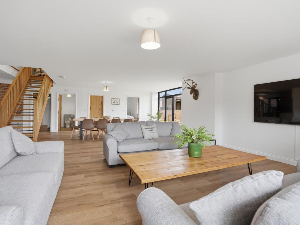 a living room with couches and a coffee table at Partridge Barn - Uk52217 in Corton