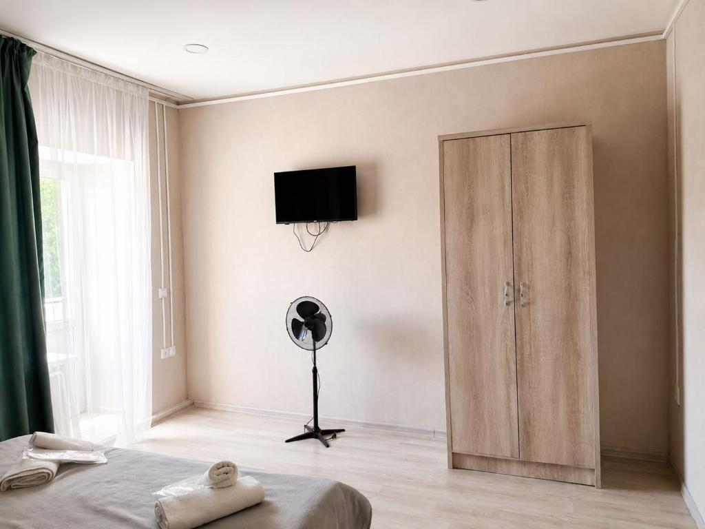 a bedroom with a room with a fan and a door at Terra Hotel in Berezovka