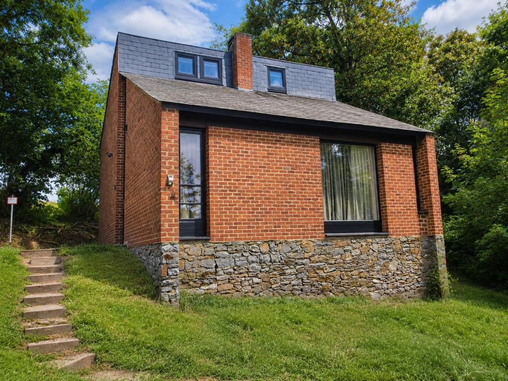 a brick house on a hill with a stone wall at Havane13 in Hastière-par-delà