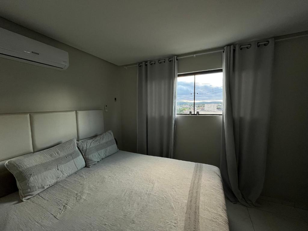 a small bedroom with a bed and a window at Suite Master Casa Luz in Garanhuns