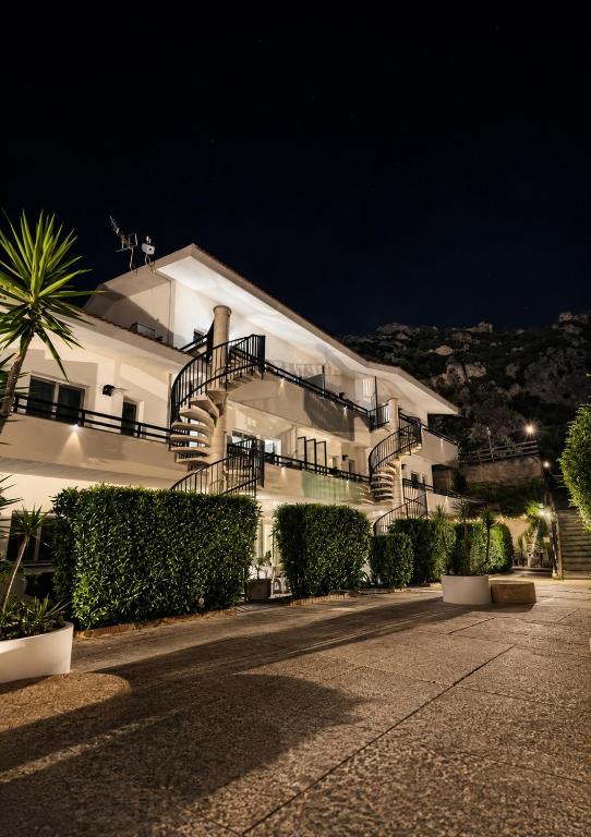 a large white building with stairs on it at night at Albatros Apartments in Licata