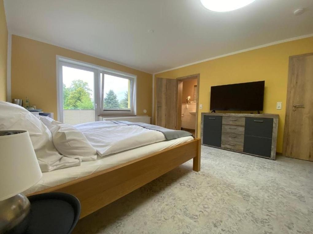 a bedroom with a large bed and a flat screen tv at Vorsicht Hôtel in Deyelsdorf
