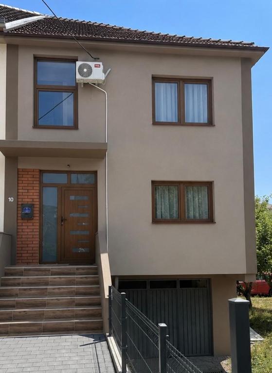 a house with a door and a porch and stairs at Apartmani Dana in Vranje