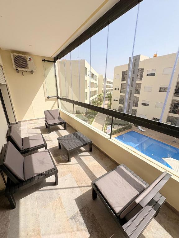a balcony with chairs and a pool in a building at Magic House T5 -El Mansouria in Mansouria