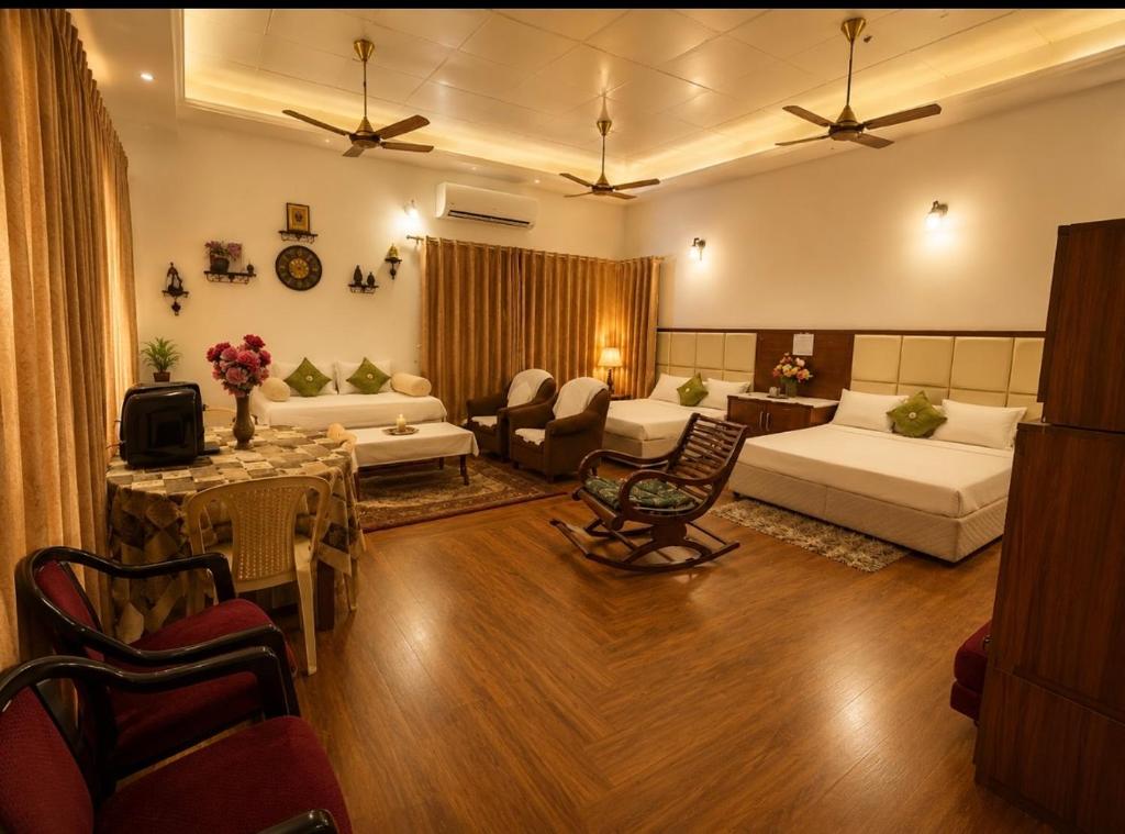 a living room with two beds and a couch and a table at White View Park in Dharmsāla