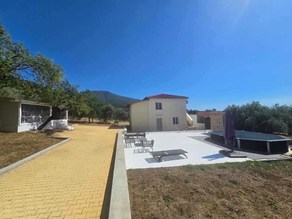 a patio with tables and chairs and a building at Olive Hill Guest House in Limenas