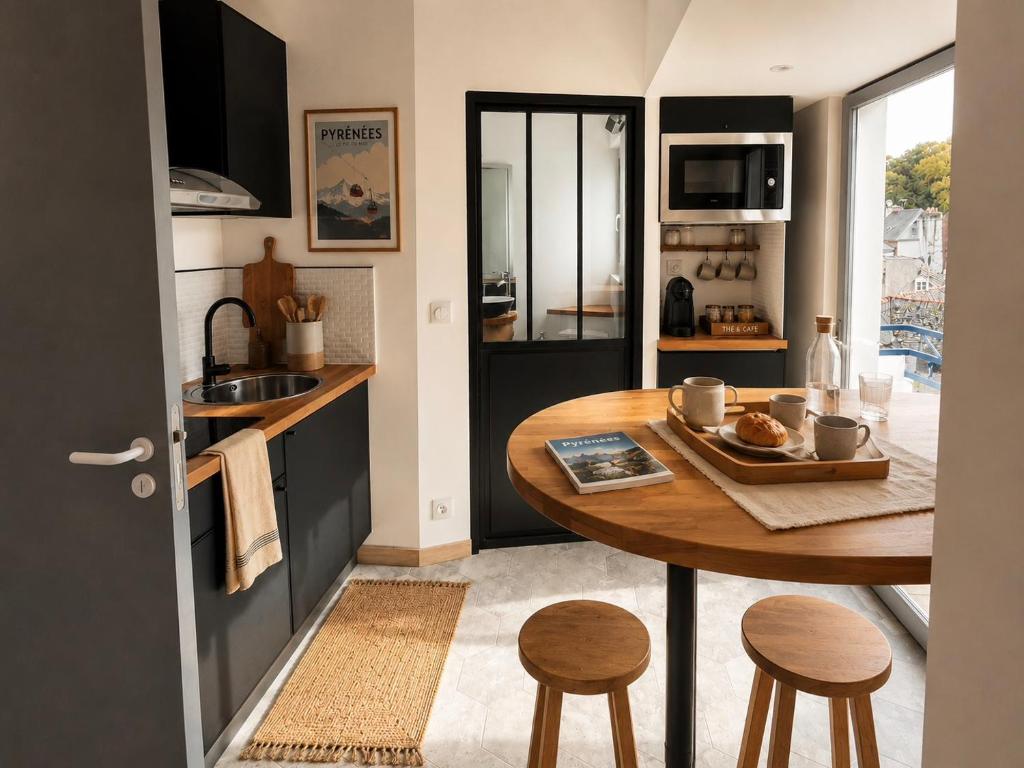 a small kitchen with a wooden table and stools at Le Parvis de PONT-AVEN in Pont-Aven
