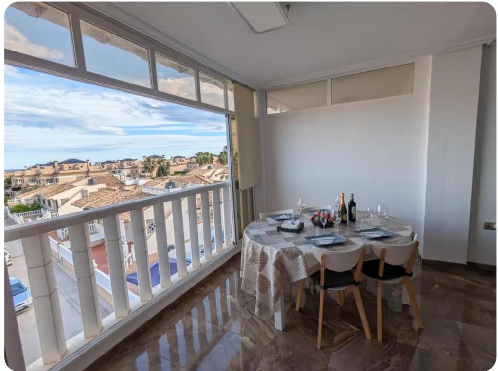a dining room with a table and a large window at Casa Lyngra in Orihuela Costa