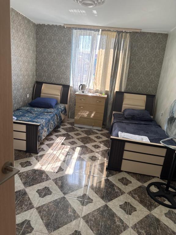 a bedroom with two beds and a tiled floor at gest house in Pʼarakʼar