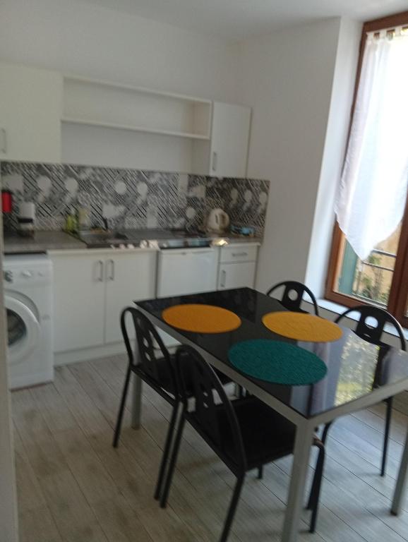 a kitchen with a table and chairs in a kitchen at Fernand Villard in La Souterraine