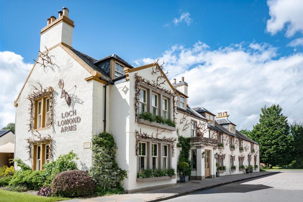 a large white building with plants on the windows at The Loch Lomond Arms Hotel in Luss