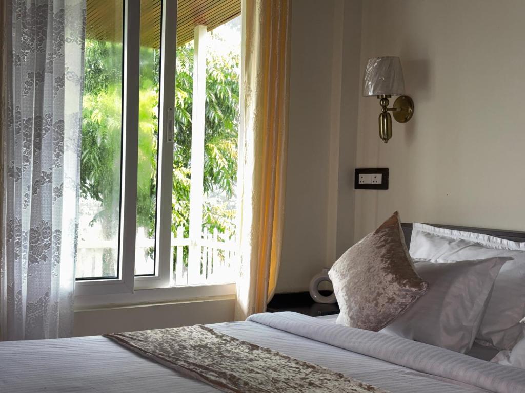 a bedroom with a bed and a large window at The Hillshade villa in Borpāni