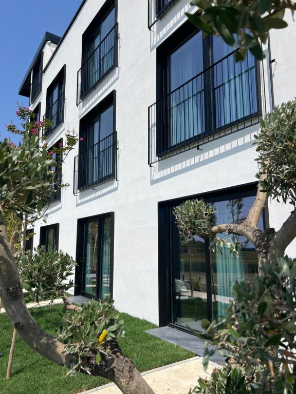 an apartment building with black windows and green grass at Eden Hotel in Rrogozhinë