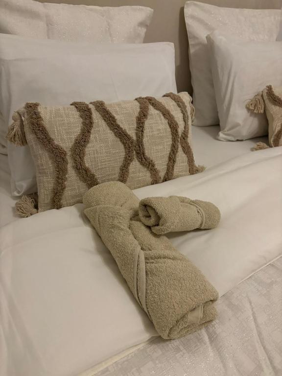 a white bed with a blanket and towels on it at Maison de charme avec Jacuzzi privé in Sarcelles
