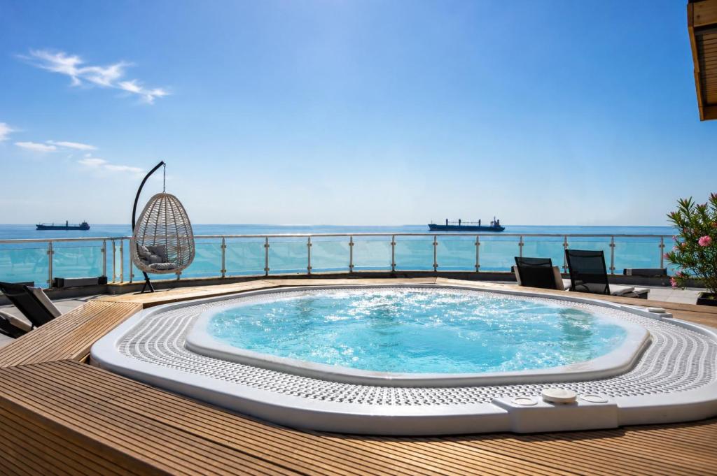 a swimming pool on a deck with the ocean in the background at Family Hotel Albizia Beach in Varna City