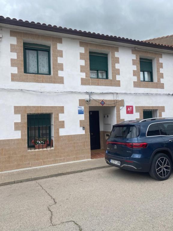 a blue car parked in front of a building at El Doblao del Rey in Torrejón del Rey