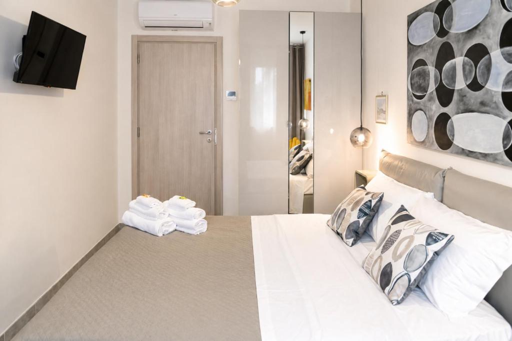 a bedroom with a white bed and a tv on the wall at Hotiday Ferrara Centro in Ferrara