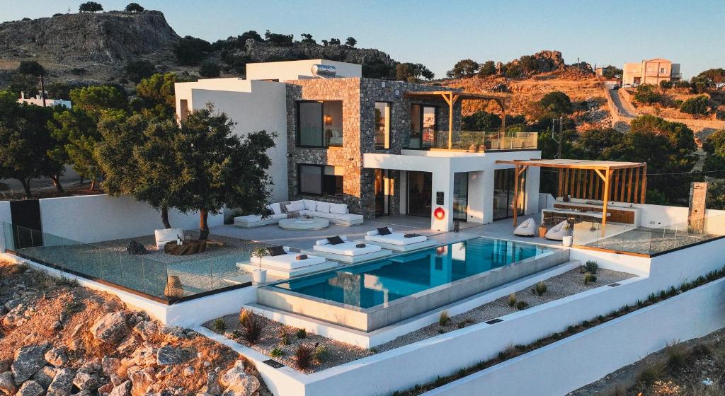 an aerial view of a house with a swimming pool at Aethra Villa - Infinity Pool & Panoramic Sea View in Pefki