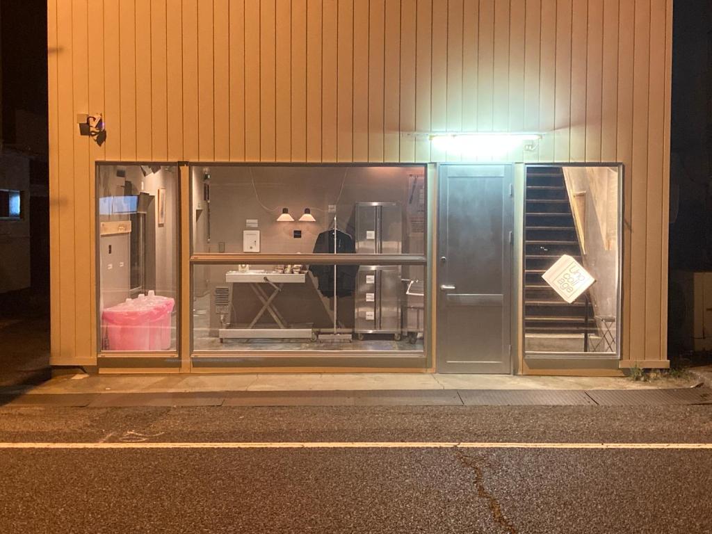 a store window with a sign in it at night at 8月1日オープン クリエイターズinn 宇野港近い トイレ風呂部屋にあり Uno collage in Tamano