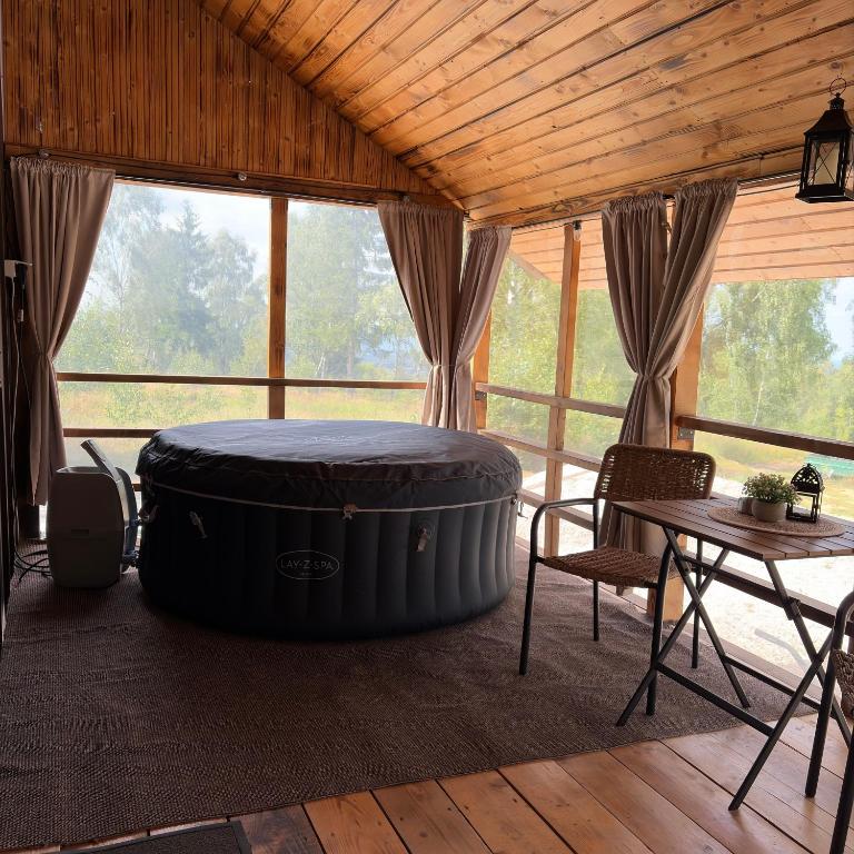 a room with a large tub in a room with a table at Little H Family in Dealu Mare