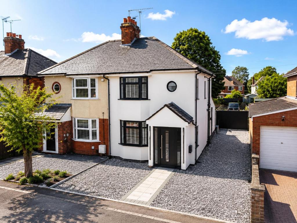 an exterior view of a white house with a driveway at Super Modern 3 bedroom semi-detached. in Rugby