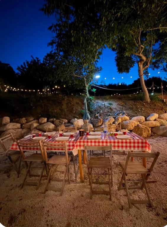 a table with chairs and a table with a red and white checkered table at Little fox in Miglianico