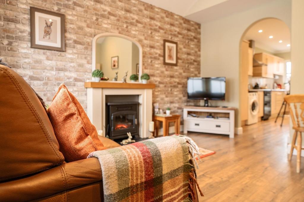 a living room with a couch and a fireplace at Central Ripon - Sleeps 3 - Garden - Pet Friendly in Ripon