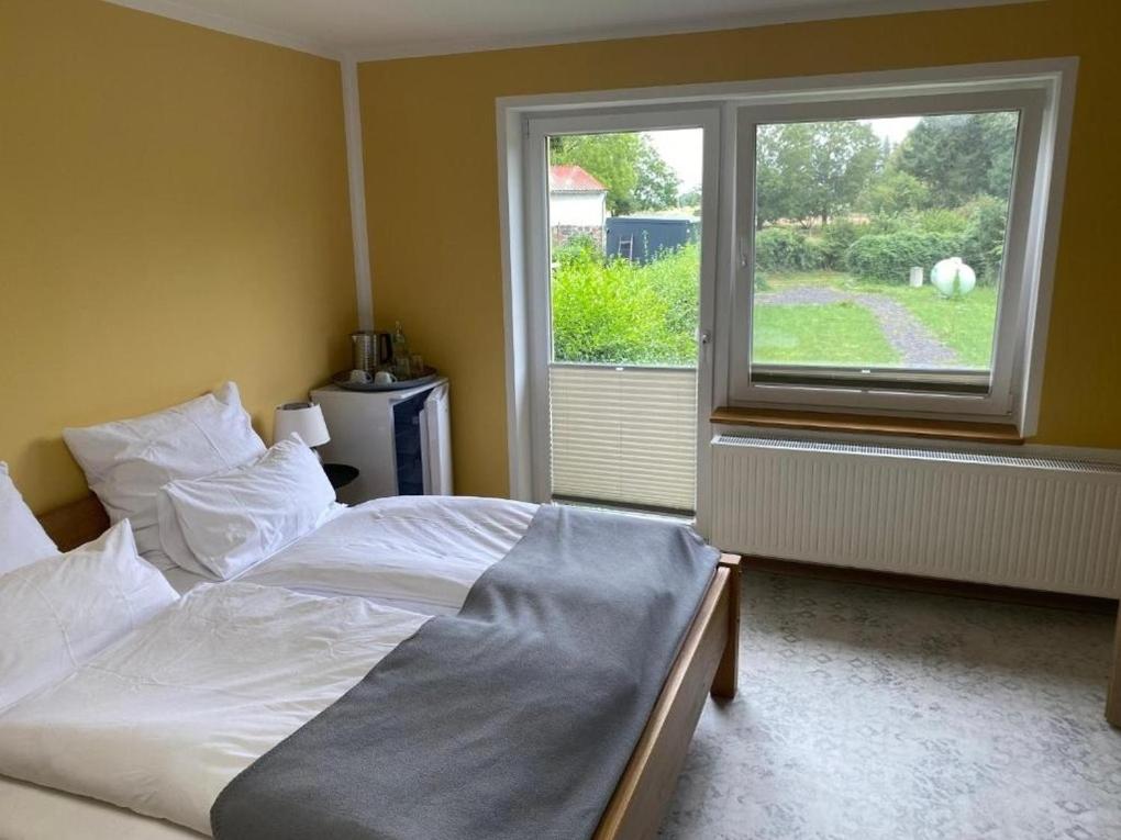 a bedroom with a white bed and a window at Ferienwohnung Vorsicht Hotel in Deyelsdorf