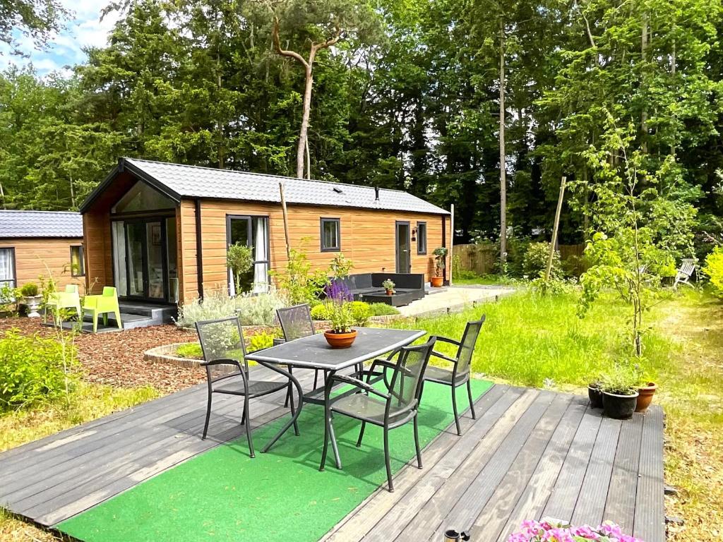 a table and chairs on a deck with a cabin at Zonnestraal in Harderwijk