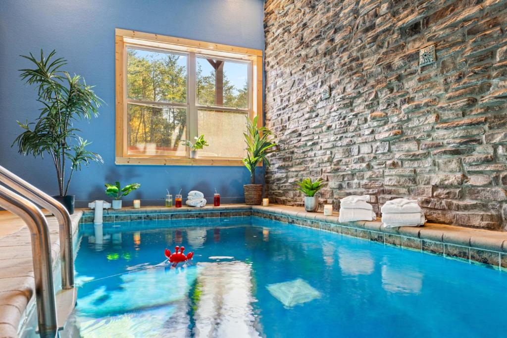 a swimming pool in a house with a brick wall at Rustic Mountain Retreat by Ghosal Luxury Lodging in Pigeon Forge