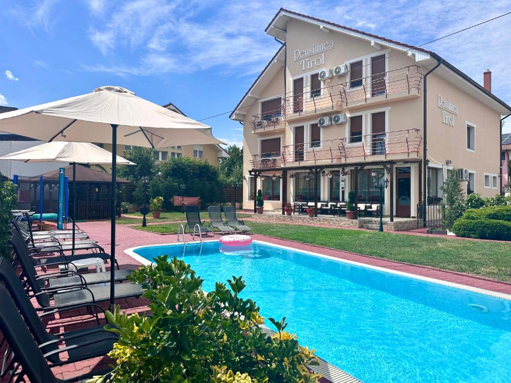a resort with a swimming pool and a building at Pensiunea Tirol Baile Felix in Baile Felix