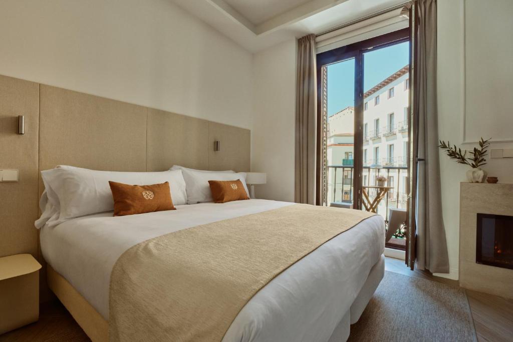 a bedroom with a large bed and a fireplace at Glinter Barrio de las Letras - Apartments in Madrid