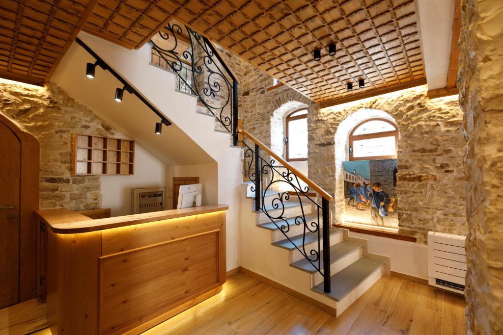 a staircase in a house with a stone wall at Hotel Kashah in Gjirokastër