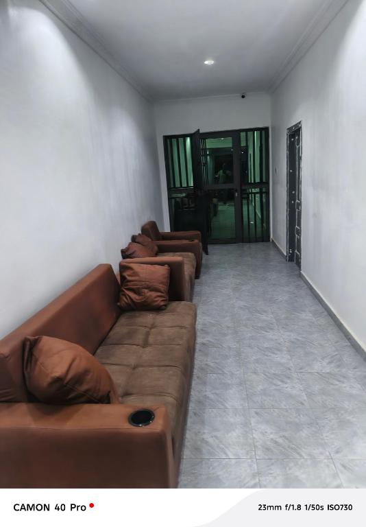 a living room with brown leather couches in it at Atupim Royal in Janman