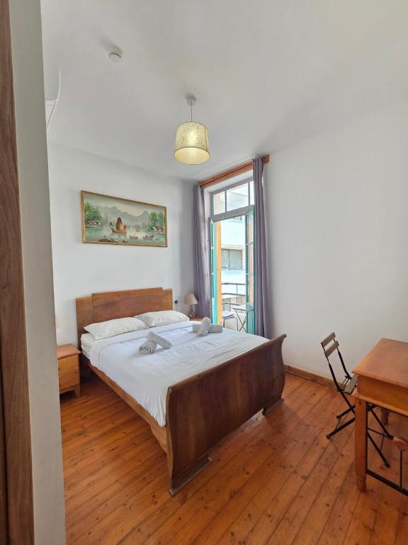 a bedroom with a bed and a desk and a window at Harrys Inn Guesthouse in Larnaca