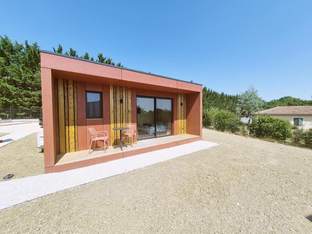 a small house with yellow curtains and a table and chairs at KOARI - Studio Clim, Piscine in Auch