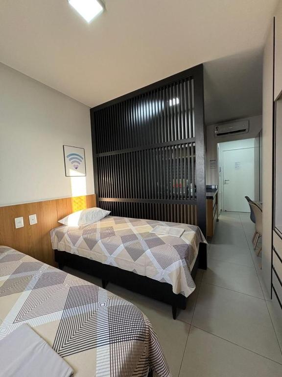 a bedroom with two beds and a desk in it at Westfit Barreto 01 in Mossoró