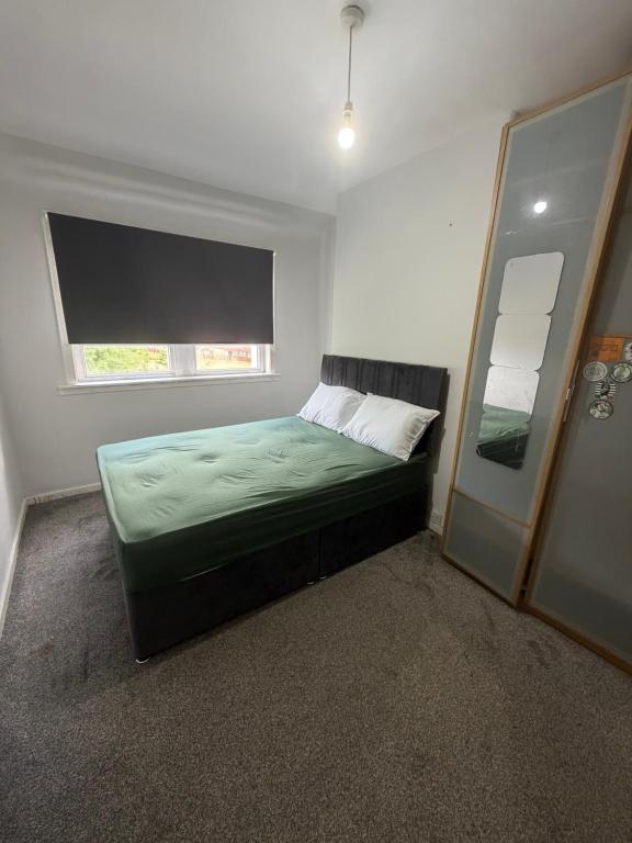 a small bedroom with a bed and a window at Glasgow Airport in Glasgow