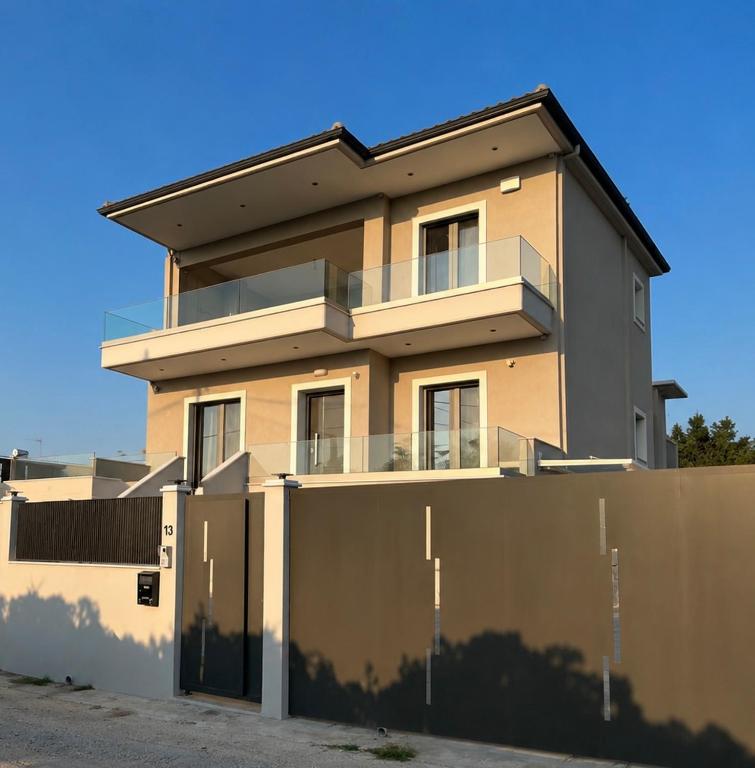a house with a fence in front of it at Luxury Family Villa near beach in Lechaio